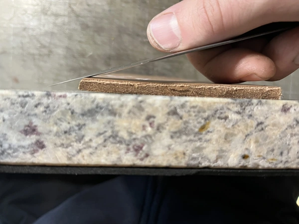 photo of TINA 270G, a straight knife, held as if to skive on a marble slab